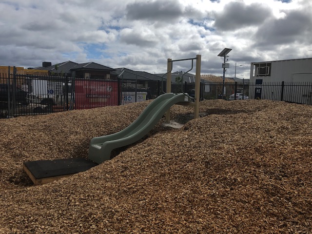 The child slide located in the outdoor play area.